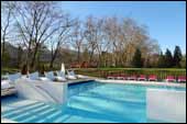 La piscina exterior climatiza sus aguas a 25� con el calor de las aguas termales. Al fondo entre los arboles se ve un poco el torre�n del Castillo de San Juan de Priorio.
